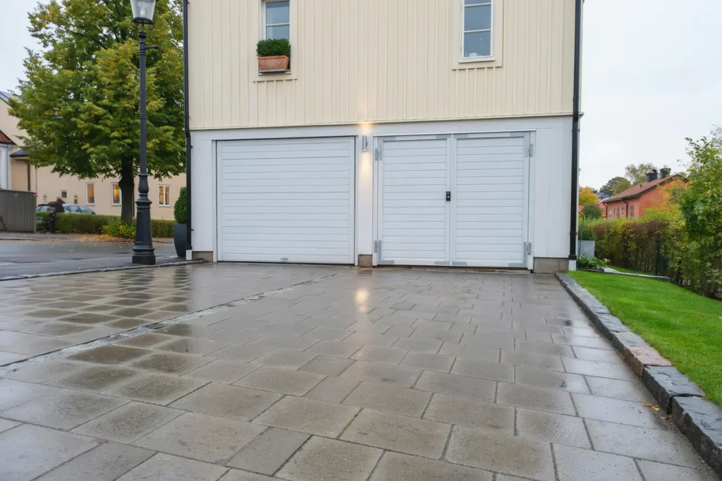 renoverad garageinfart med sm gatsten i gamla enskede